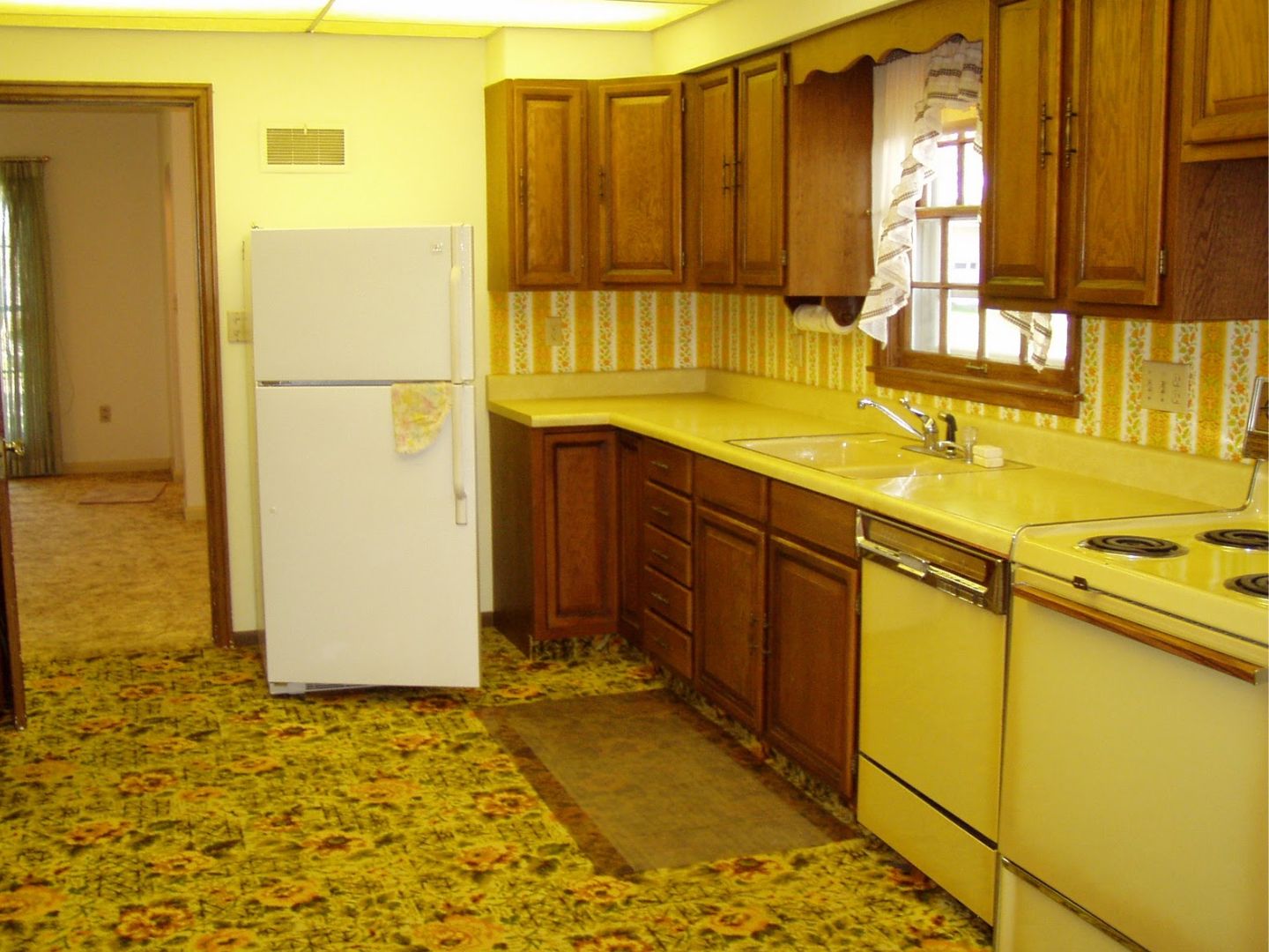 Dated 1970s kitchen with vintage yellow cabinets showing common reasons Bay Area homeowners remodel