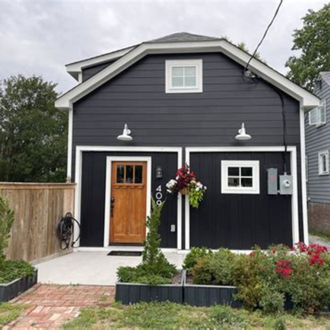 Dark exterior garage conversion ADU with wood door in residential Bay Area neighborhood
