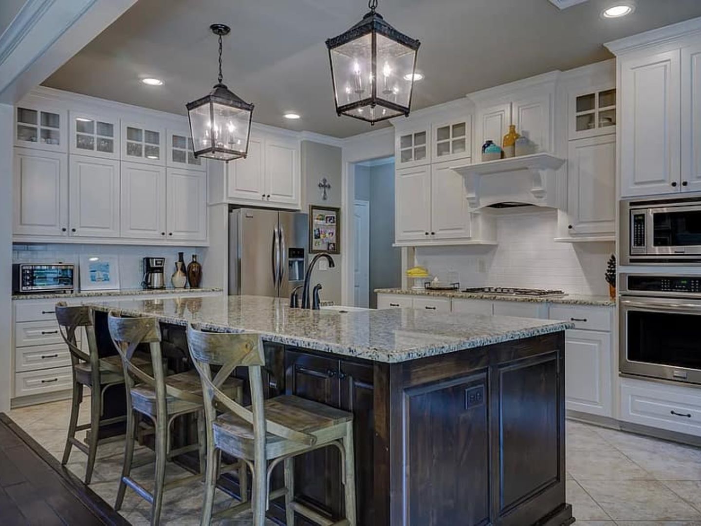 Completed kitchen remodel with white cabinets and large island by Mendez and Sons Construction