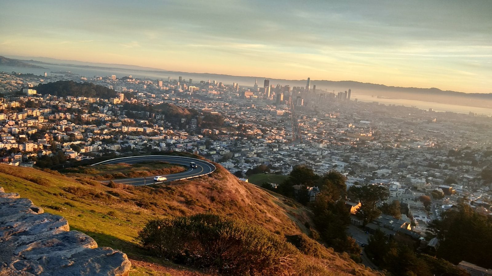 Panoramic view of San Francisco Bay Area at golden hour showing city skyline and residential neighborhoods